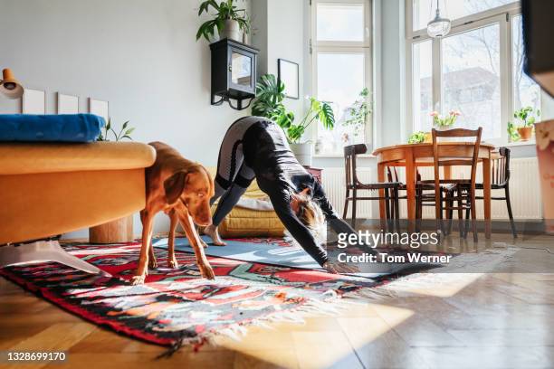 single mom doing yoga in living room at home - salle yoga photos et images de collection