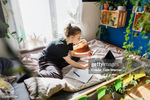 teenage girl studying in bedroom using zoom on laptop - teen sleeping bedroom stock pictures, royalty-free photos & images