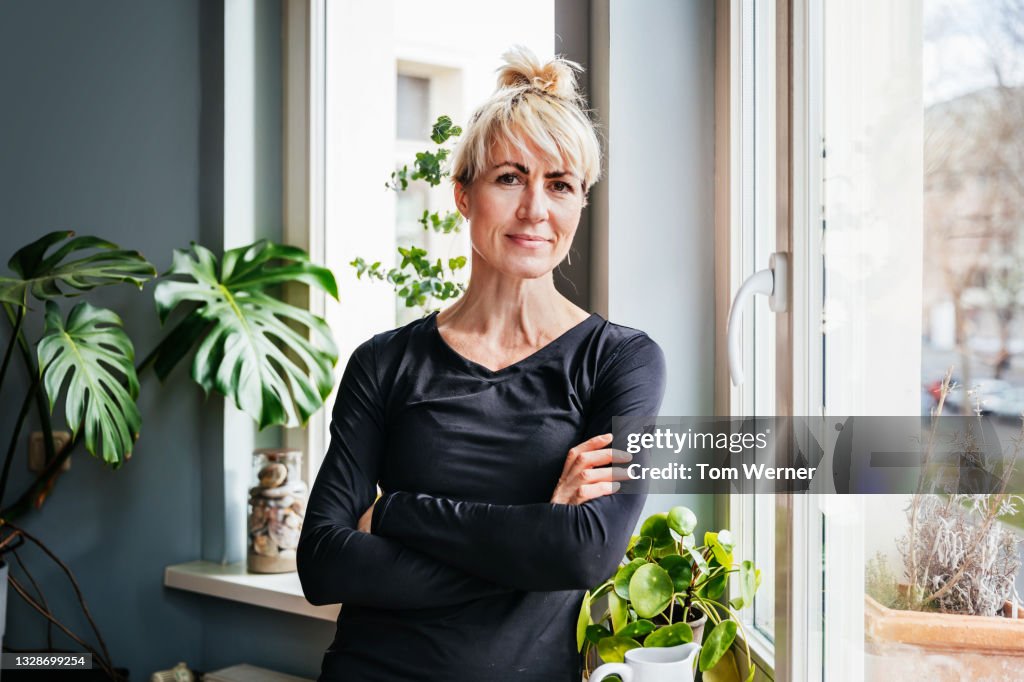 Portrait Of Single Mom Standing By Living Room Window