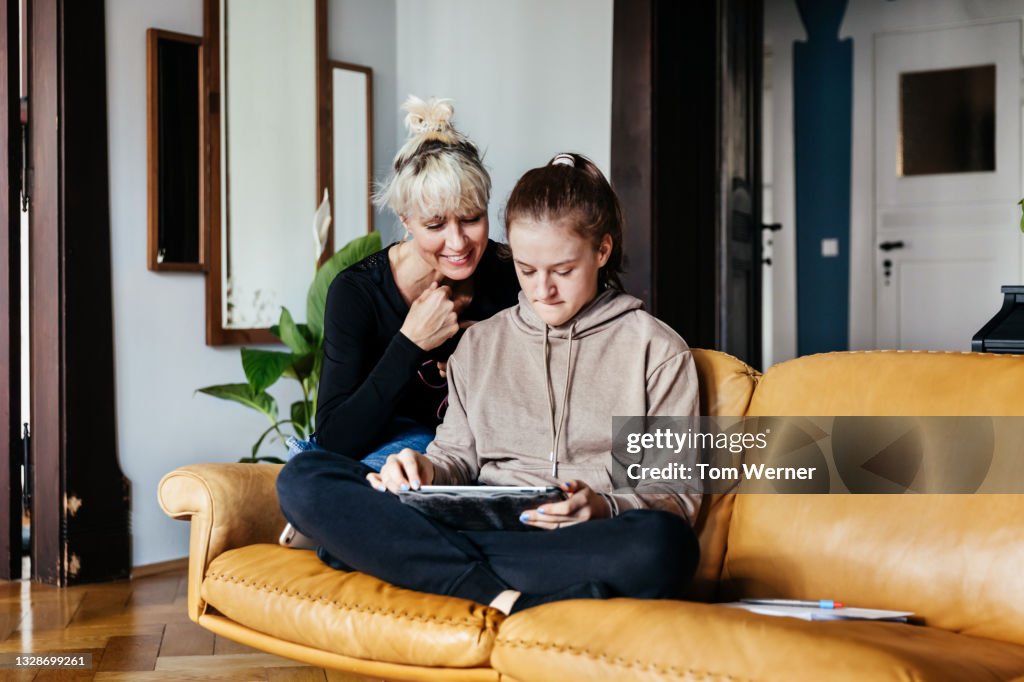 Single Mom Helping Daughter With Homework In Living Room