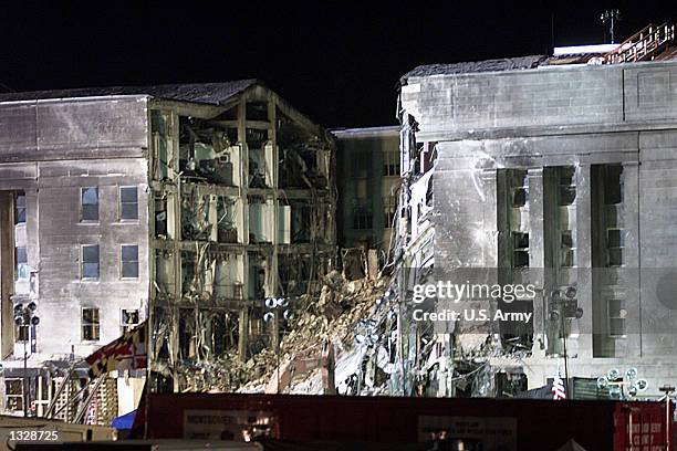 The portion of the Pentagon that was hit by a hijacked airplane September 11, 2001 is lit up by artificial light as round-the-clock recovery efforts...