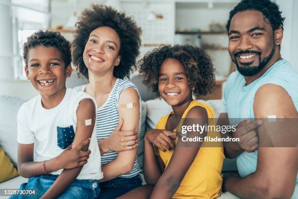 portrait of a vaccinated family - covid vaccine bandage stock pictures, royalty-free photos & images