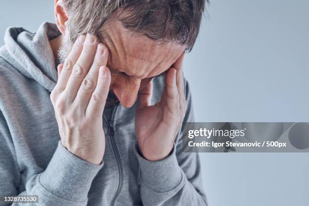 senior man touching his head,serbia - chronic fatigue stock-fotos und bilder