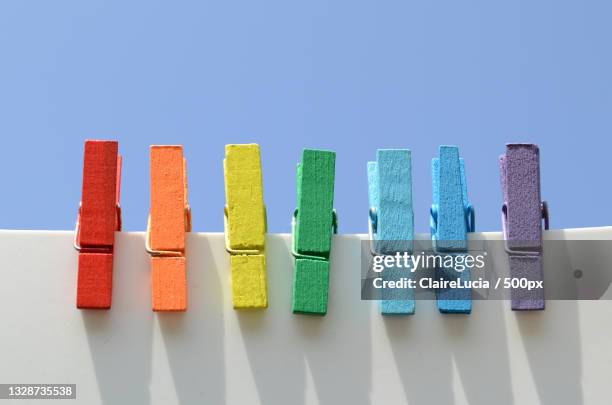 close-up of clothespins on clothesline against clear blue sky - 洗濯バサミ ストックフォトと画像