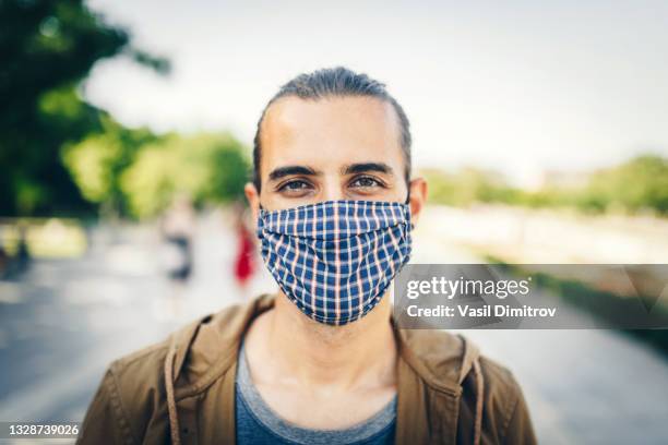 jeune homme avec un masque dans la ville. pollution de l’air / protection contre le coronavirus / concept de protestation. - air pollution photos et images de collection