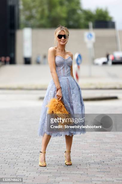 Influencer Gitta Banko wearing a bubble low ponytail hairstyle, a periwinkle colored strapless lace midi dress "u2018Olivia Blue"u2019 with...