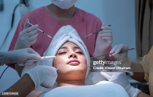 conceptual beauty and cosmetology image of the hands of several beauticians holding their respective equipment. - odontología cosmética fotografías e imágenes de stock