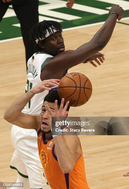 Jrue Holiday of the Milwaukee Bucks knocks the ball out of the hands of Devin Booker of the Phoenix Suns in Game Four of the NBA Finals at Fiserv...