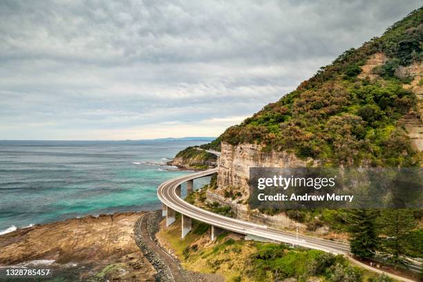 sea cliff bridge, coastal road mountain, overcast weather - road trip australia stockfoto's en -beelden