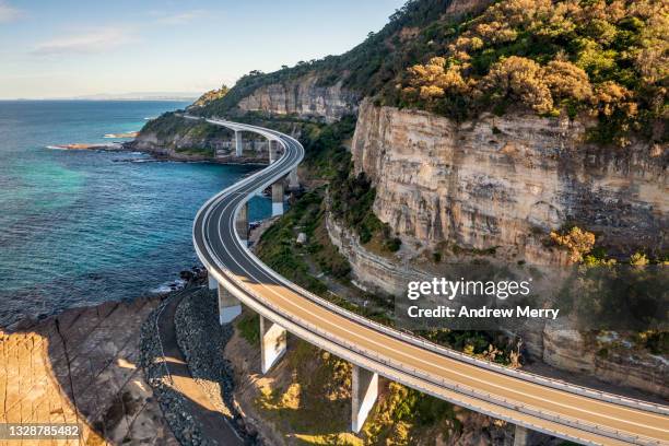 sea cliff bridge, rocky coast road, highway and mountain, aerial view - rocky coastline - fotografias e filmes do acervo