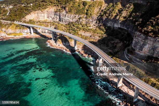 sea cliff bridge, coastal road, highway, aerial view - driving car australia road copy space sunlight travel destinations colour image day getting stock pictures, royalty-free photos & images
