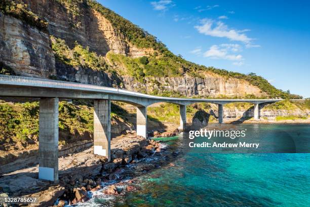 sea cliff bridge rocky coast road, mountain and turquoise ocean - sea cliff bridge stockfoto's en -beelden