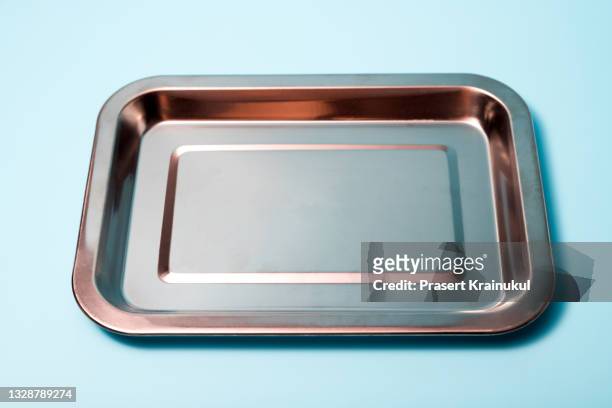 empty baking tray on blue background - plateau stockfoto's en -beelden