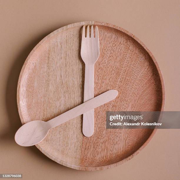 16:8 fasting diet concept. wooden plate and spoon, fork. copy space, top view - jeûner photos et images de collection