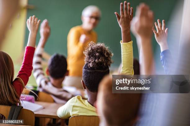 rückansicht von schülern, die ihre hände heben, um die frage des lehrers zu einer klasse zu beantworten. - girls hands behind back stock-fotos und bilder