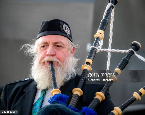scottish piper marches in a parade to celebrate the winter solstice. - piper stock pictures, royalty-free photos & images