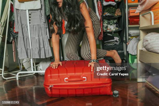 latina young woman packing luggage for  holidays in her bedroom - suitcase packing stockfoto's en -beelden