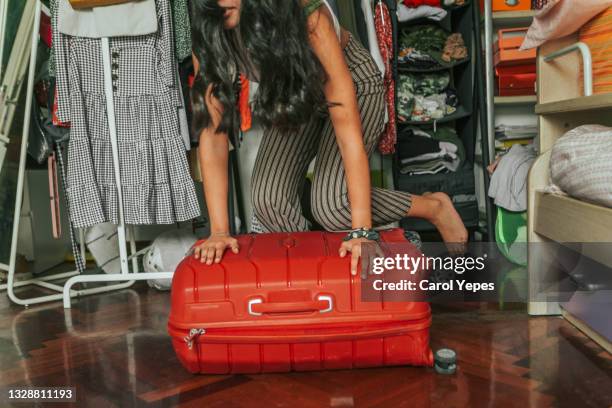 latina young woman packing luggage for  holidays in her bedroom - pack 個照片及圖片檔