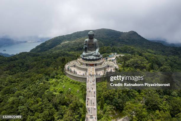 aerial drone view of tian tan buddha in foggy day scene, also known as the big buddha. hong kong, china. - boeddha stockfoto's en -beelden