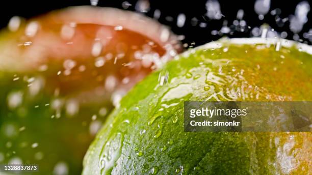 water droplets gliding down a mango - mangoes stock pictures, royalty-free photos & images