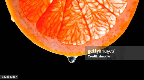 goccia d'acqua che cade da una fetta di pompelmo - pompelmo foto e immagini stock