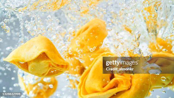 tortellini pasta falling into boiling water - tortellini bildbanksfoton och bilder