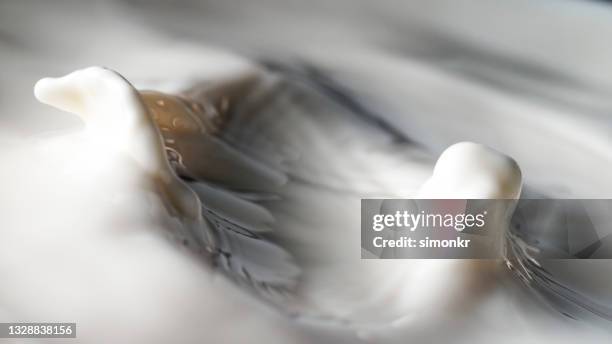 milk splashing in cup - milk full frame stock pictures, royalty-free photos & images