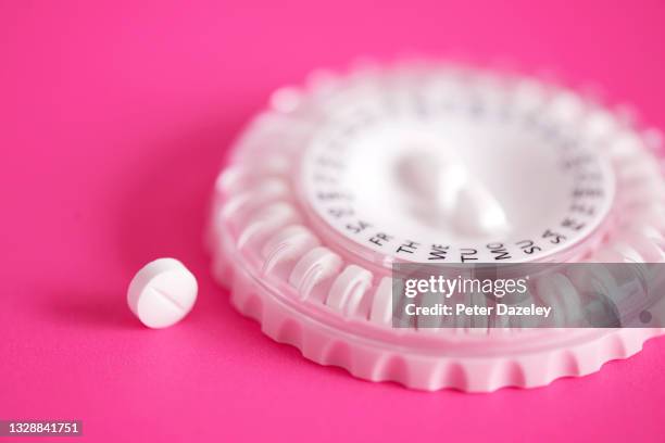 hrt pills on pink background - hrt pill stockfoto's en -beelden