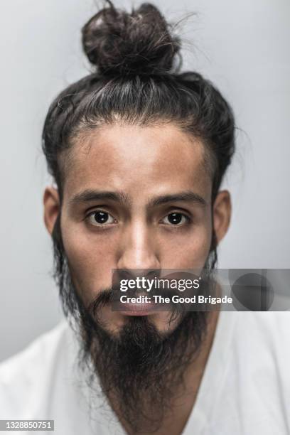 portrait of young man with hair in bun - man bun hair photos et images de collection