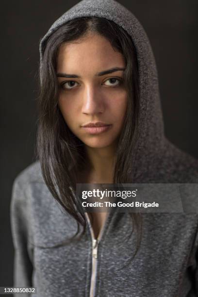 portrait of confident young woman wearing hooded shirt - hoodie stock pictures, royalty-free photos & images