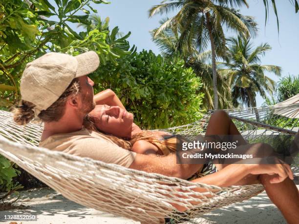 romantisches paar zum entspannen in der strandhängematte - indian ocean stock-fotos und bilder