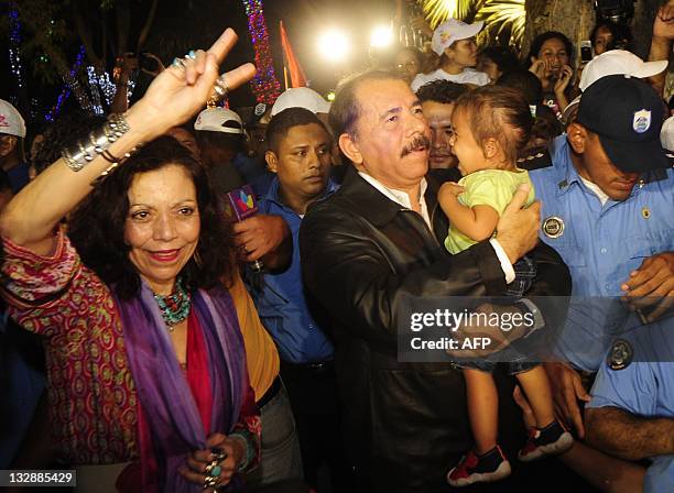 Reelected Nicaraguan President Daniel Ortega carries a girl next to supporters after a message to the nation, two day after of the presidential...