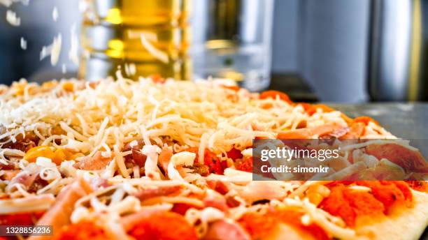cheese falling onto a pizza - grated cheese falling stock pictures, royalty-free photos & images