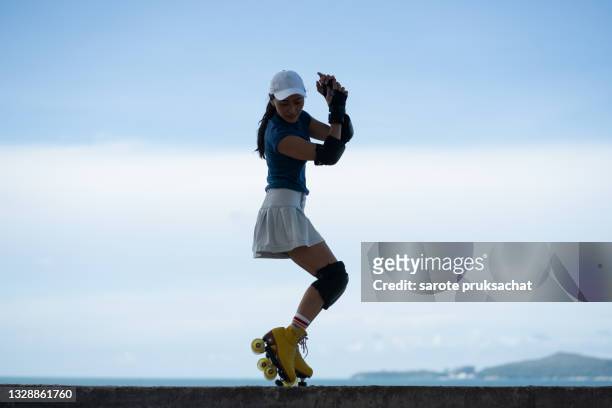 asian woman roller skating . - roller skating stock pictures, royalty-free photos & images