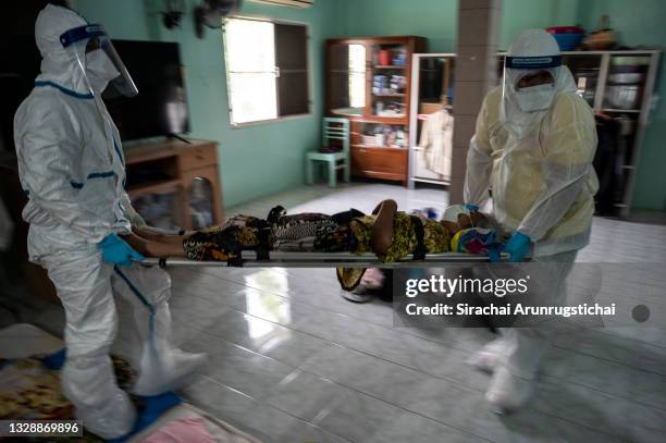 Sanguan Thaveeratdamrong , a Covid-19 patient with Alzheimer's disease is seen being carried on a stretcher by healthcare workers after getting a...