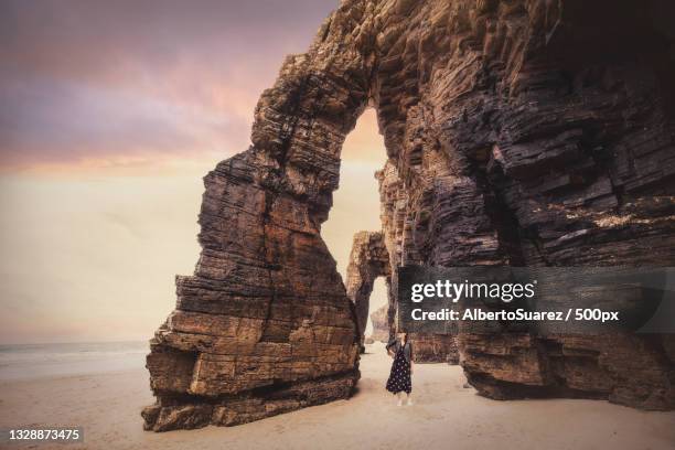 rear view of woman standing at beach against sky during sunset,ribadeo,galicia,spain - cathedral bildbanksfoton och bilder