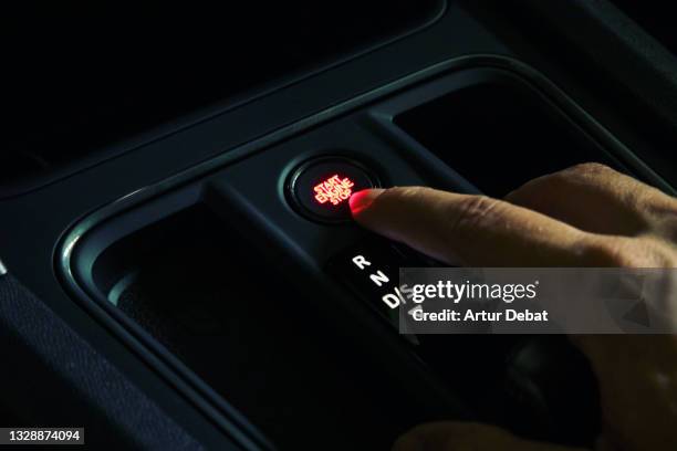 turning on hybrid car pressing button engine. - car keys hand foto e immagini stock