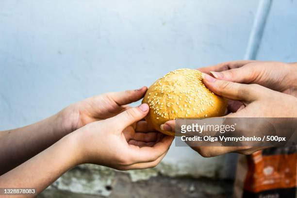 cropped hands of woman giving burger to man - religious equipment stock pictures, royalty-free photos & images