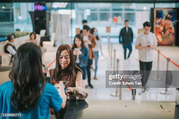 asian chinese female audience  in front ticket counter buying movie tickets , popcorns before movie show time at movie theater cinema - snackbar stock pictures, royalty-free photos & images