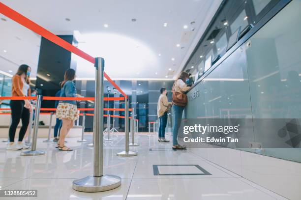 bajo ángulo de la audiencia china asiática esperando en la fila en el mostrador de entradas de venta de entradas de cine y palomitas de maíz beber pago sin contacto antes de la hora del espectáculo de cine en el cine de cine - ticket counter fotografías e imágenes de stock