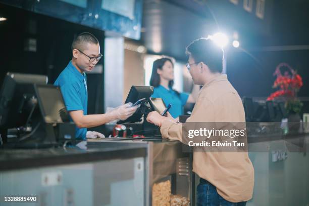 asian chinese youth adult buying movie tickets , popcorn and drink before cinema movie show time at movie theater - theatre program stock pictures, royalty-free photos & images