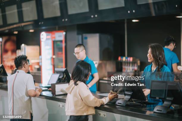 asian chinese customers buying movie tickets from cinema movie theater ticket counter - fastfoodrestaurant stockfoto's en -beelden