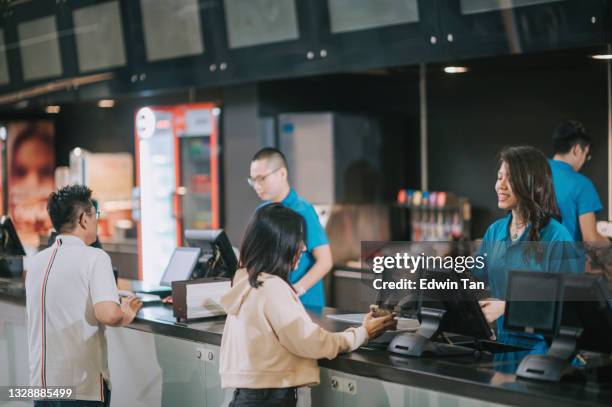 asian chinese customers buying movie tickets from cinema movie theater ticket counter - movie counter stock pictures, royalty-free photos & images