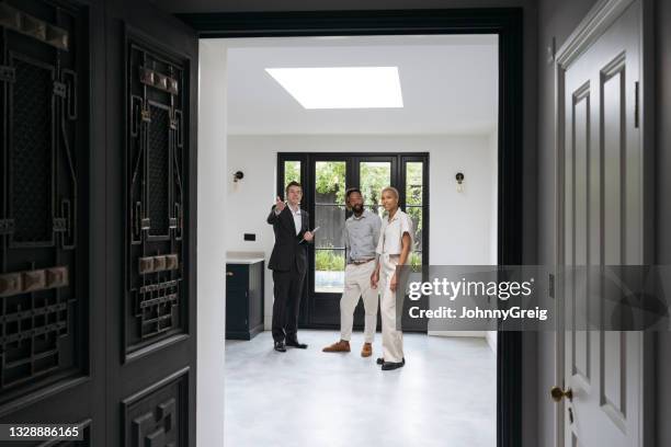中期成人の黒いカップルに豪華な家を示す男性の不動産業者 - day uk show ストックフォトと画像