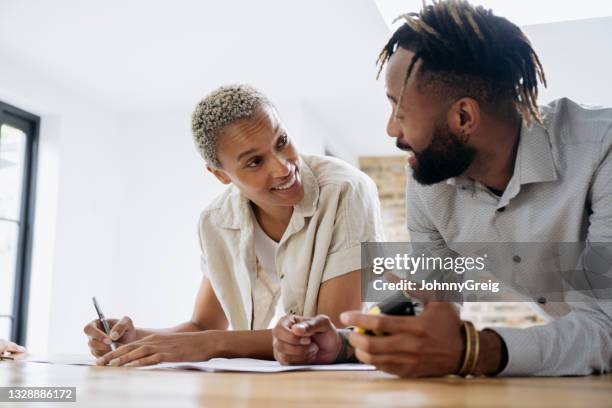 black couple smiling as they sign real estate paperwork - couple real life stockfoto's en -beelden
