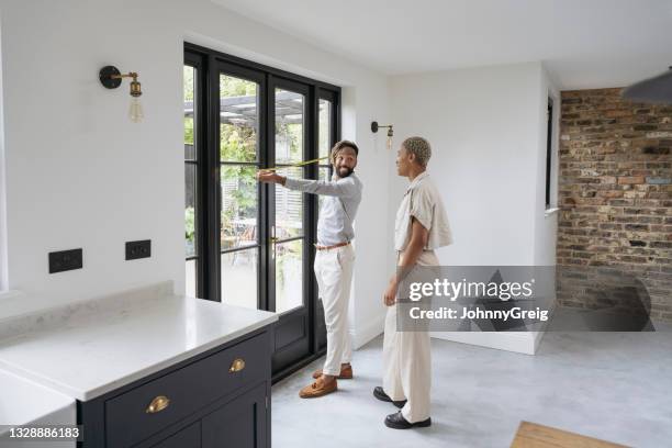kaufinteressenten, die messungen in luxusimmobilien durchführen - zementboden stock-fotos und bilder