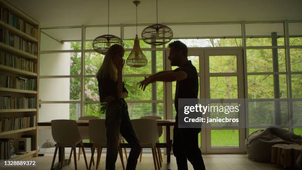 paar mit emotionaler, aggressiver diskussion. silhouetten im wohnzimmer - forced marriage stock-fotos und bilder