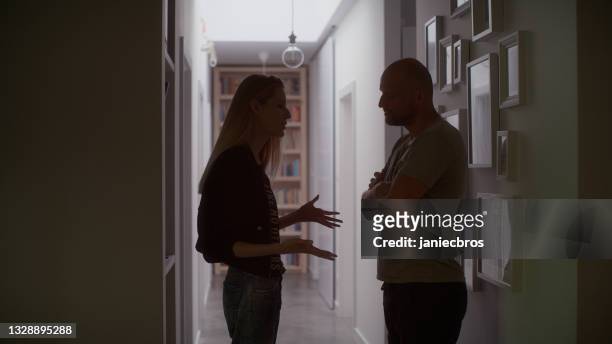 couple having emotional, aggressive discussion. silhouettes in claustrophobic hallway - victim silhouette stock pictures, royalty-free photos & images