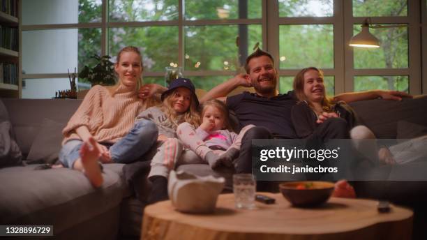 watching tv at home. family with three daughters spending time together. - guardians of heritage screening by german tv channel history stockfoto's en -beelden