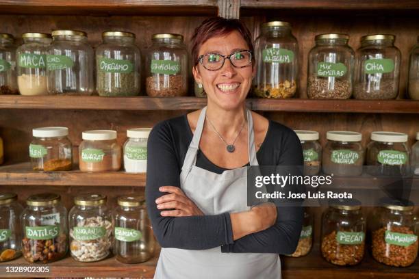 young latin woman owner working in grocery store, portrait of a happy latin american business owner working at shop and looking at the camera smiling - mini grocery store photos et images de collection